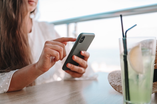 Beautiful girl uses the phone in a cafe