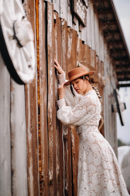 Foto bella ragazza in abito di pizzo vintage e cappello al ranch