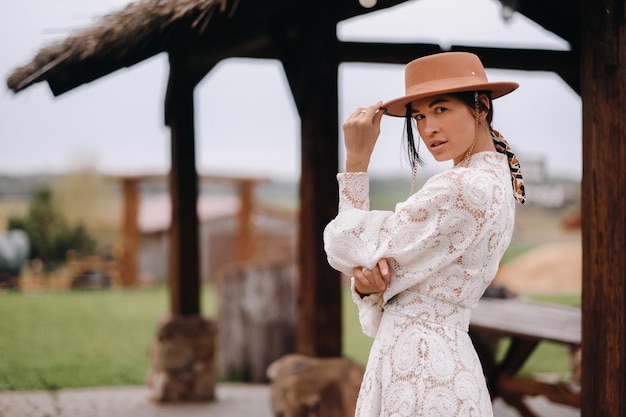 Beautiful girl in vintage lace dress and hat at the ranch