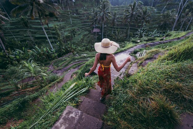 写真 ウブドのテガラランにあるバリの水田を訪れる美しい少女。人、放浪旅行、観光ライフスタイルについての概念