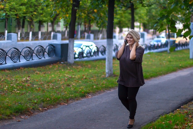 Beautiful girl walking down the street and talking on the phone