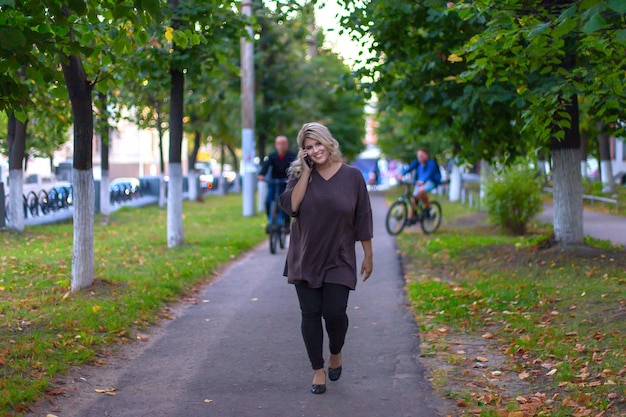 Beautiful girl walking down the street and talking on the phone