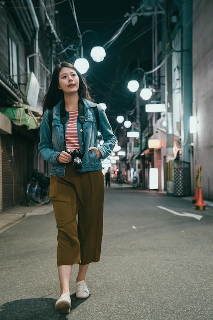 Beautiful girl walking in night street in osaka