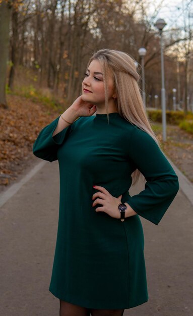 A beautiful girl walks along the alley in the autumn park