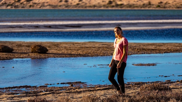 Photo beautiful girl walks at sunset on the beach at shark bay, francois peron national park