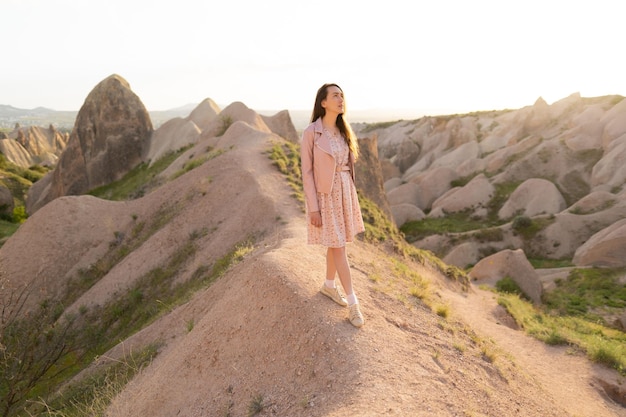 A beautiful girl walks on the top of the mountain enjoying the view