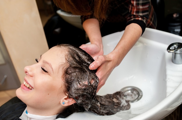 Bella ragazza lava i capelli.