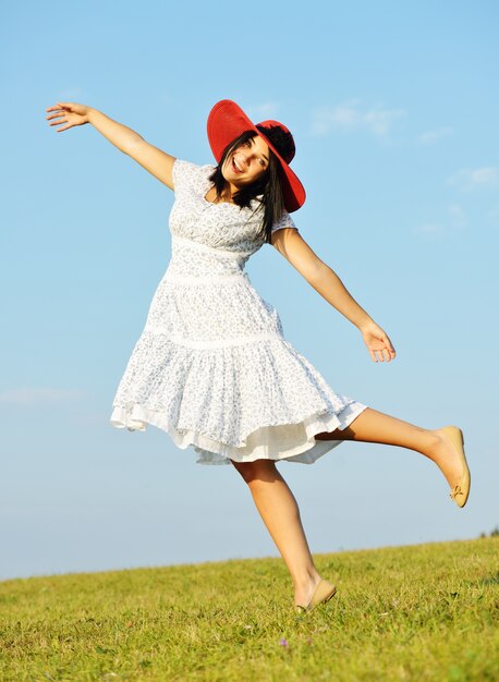 Beautiful girl wearing red hat on summer meadow