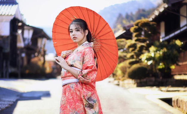 Photo beautiful girl wearing traditional japanese kimono in tsumago juku at nagano japan