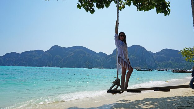 Beautiful girl in a white cape on a swing