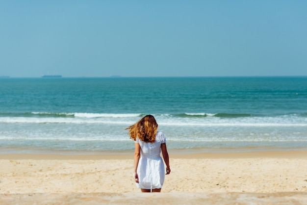 Beautiful Girl in White Dress Enjoy and Relax on The Beach