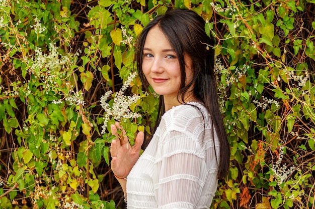 Beautiful girl in a white dress in the par