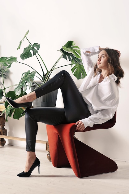 Beautiful girl in a white shirt is sitting