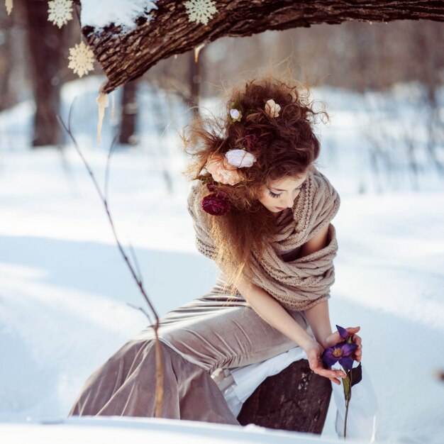 Bella ragazza nella foresta invernale