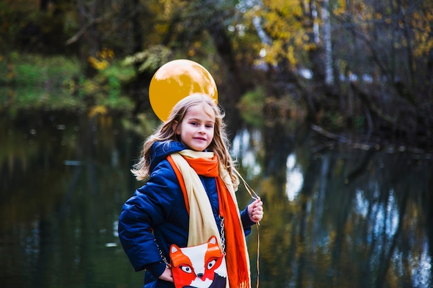 Beautiful girl with a balloon.  Portrait of a blonde girl with brown eyes with a balloon on the background of autumn. Photo shoot