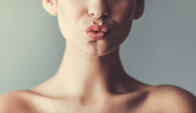 Photo beautiful girl with bare shoulders sending kiss.