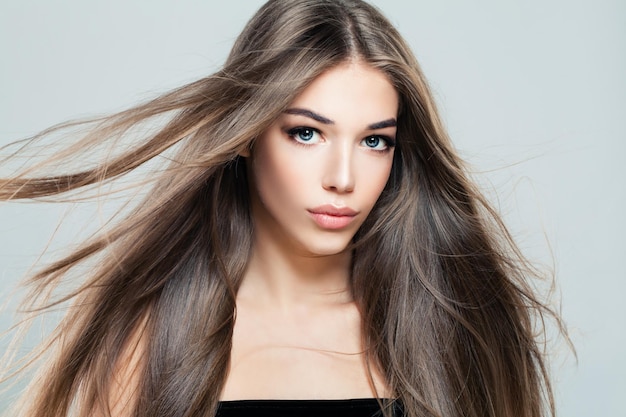 Beautiful Girl with Blowing Hair. Young Woman Fashion Model with Long Healthy Hairstyle, Beauty Salon Background
