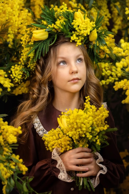 Beautiful girl with a bouquet of mimosa flowers