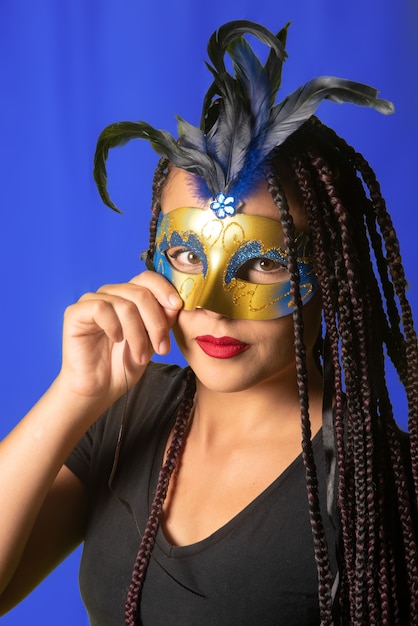 Beautiful girl with braids in her hair and carnival mask