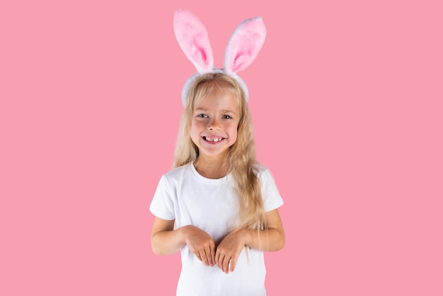 Beautiful girl with bunny ears isolated on pink background New Year and Easter concept