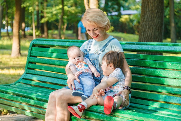 Beautiful girl with children sits on a bench in the park