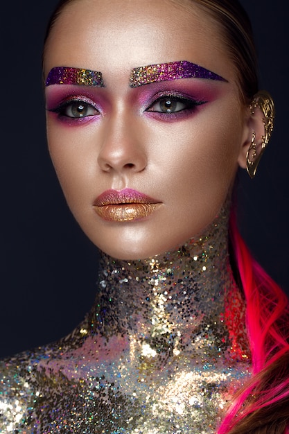 Photo beautiful girl with creative glitter makeup, sparkles, unusual eyebrows. beauty is an art face.