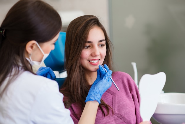 Bella ragazza con apparecchi ortodontici presso la reception dal dentista