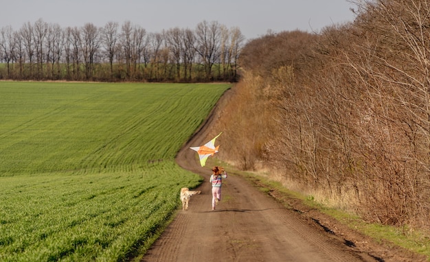 Beautiful girl with dog flying kite