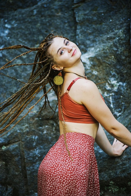 Beautiful girl with dreadlocks dressed hippie styleposes outdoors