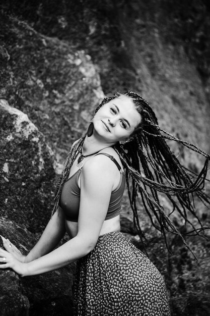 Beautiful girl with dreadlocks dressed hippie styleposes outdoors