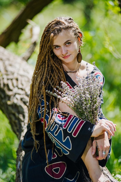 Beautiful girl with dreadlocks dressed hippie styleposes outdoors