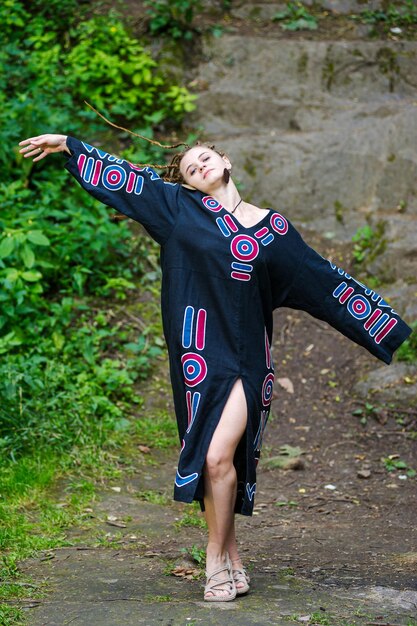 Beautiful girl with dreadlocks dressed hippie styleposes outdoors