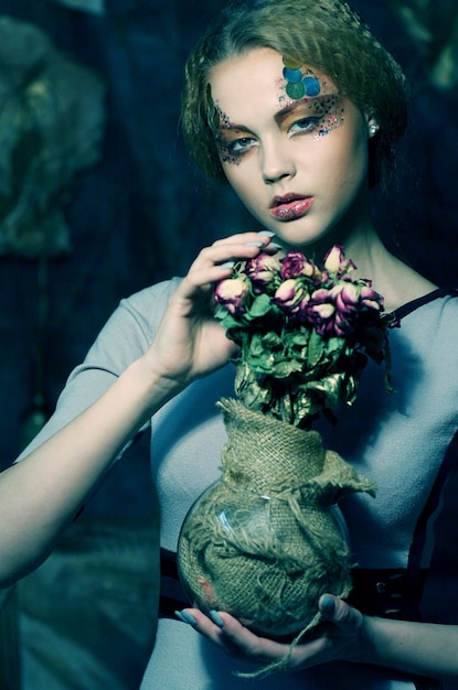 Beautiful girl with dry roses in decoration
