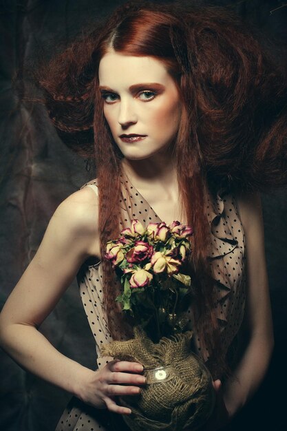 Beautiful girl with dry roses in decoration