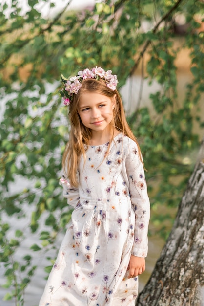 Beautiful girl with floral wreath in nature