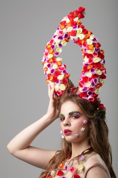 Beautiful girl with flower horns Spring model Beautiful girl with an unusual makeup