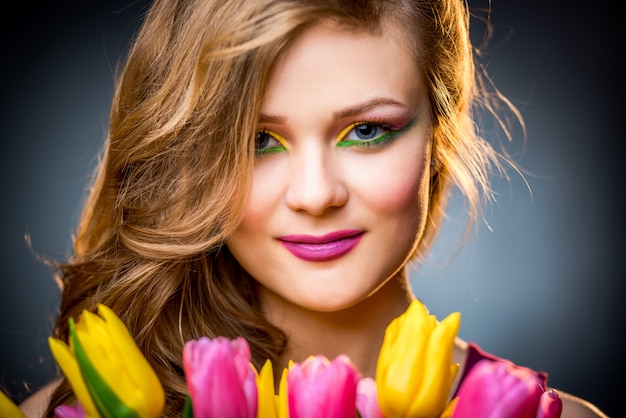 Foto bella ragazza con fiori di tulipani