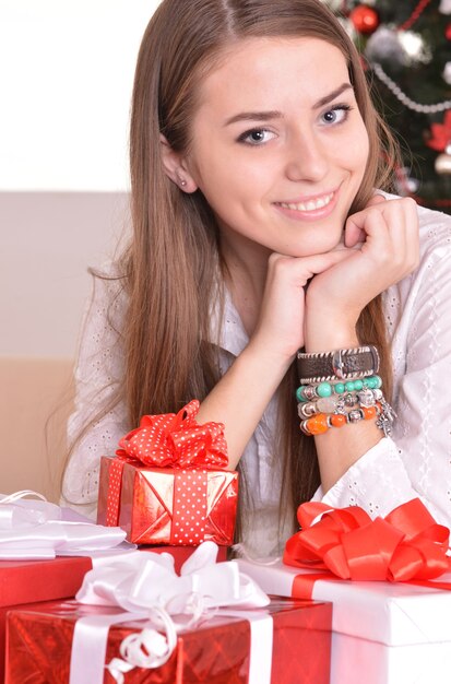 Beautiful girl with  gifts near the Christmas tree