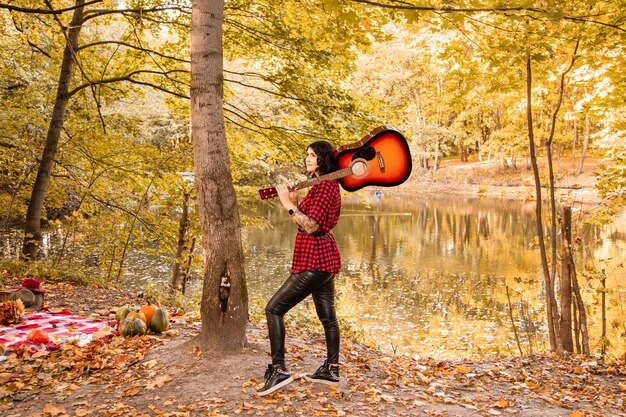 Foto bella ragazza con una chitarra su uno sfondo