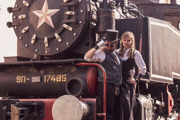 Beautiful girl with a guy couple in love in steampunk clothes