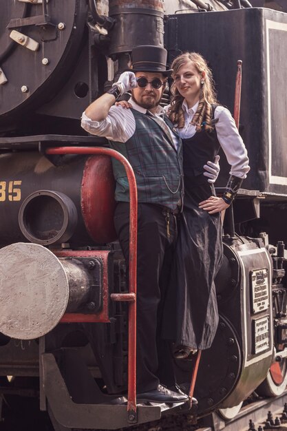 Photo beautiful girl with a guy couple in love in steampunk clothes