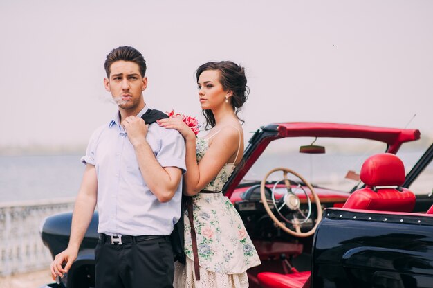 beautiful girl with a guy in a retro car