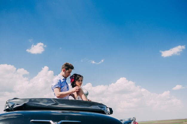 beautiful girl with a guy in a retro car