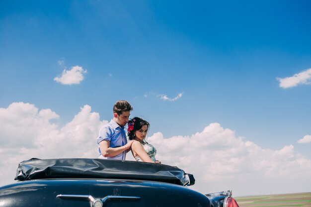 beautiful girl with a guy in a retro car