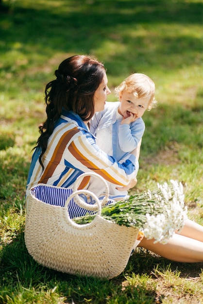 Beautiful girl with a little daughter in her arms in the park