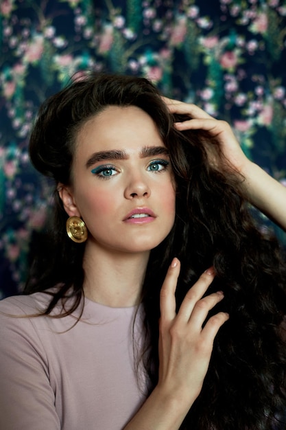 A beautiful girl with long curly hair in large gold earringsBeauty style and fashion