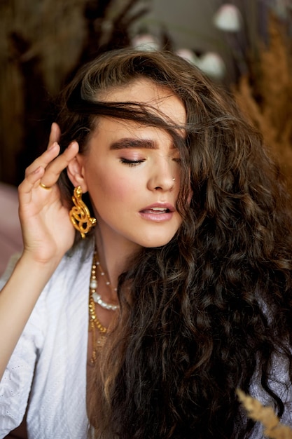 A beautiful girl with long hair corrects curls Thick eyebrows Model appearance