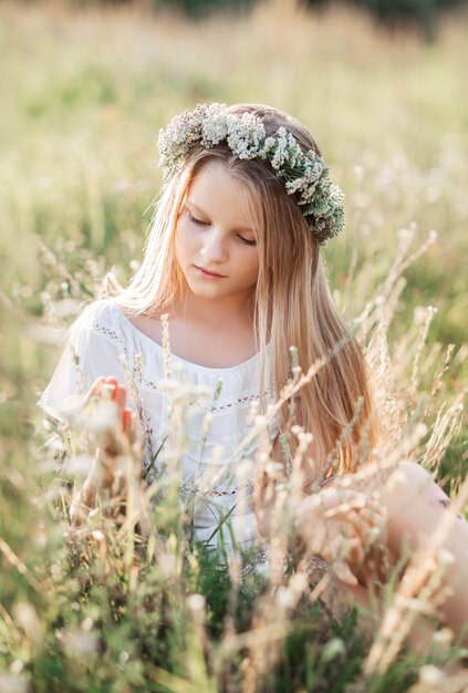 Beautiful girl with long hair in meadow flowers