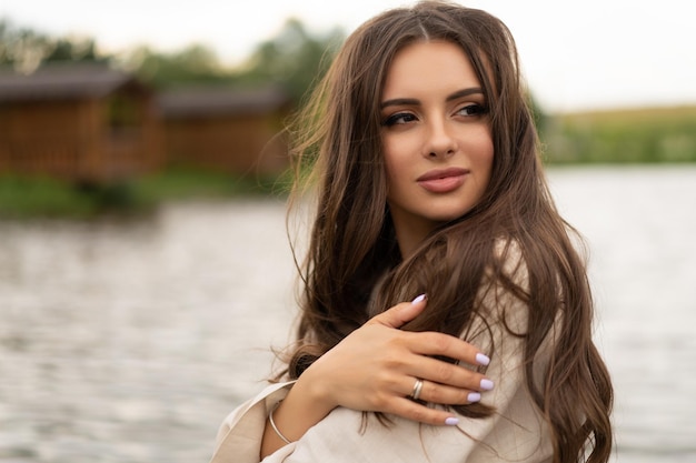 Beautiful girl with long hair posing outdoors on the lake shore