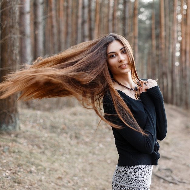 Красивая девушка с длинными волосами гуляет в парке
